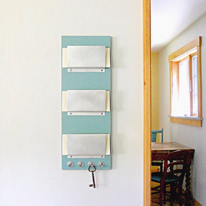 Triple mail holder near a doorway.